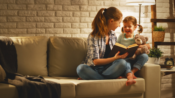 mom reading a book with her daughter before bedtime