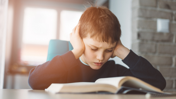 tired boy reading at a desk who does not have good sleep hygiene