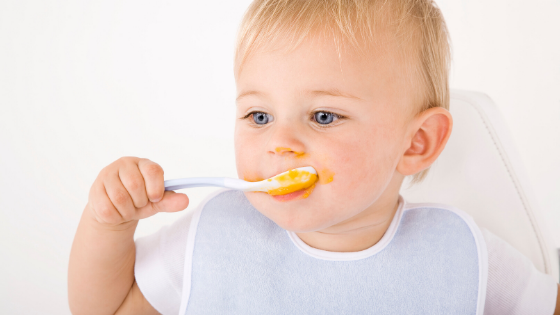 young child eating from a spoon