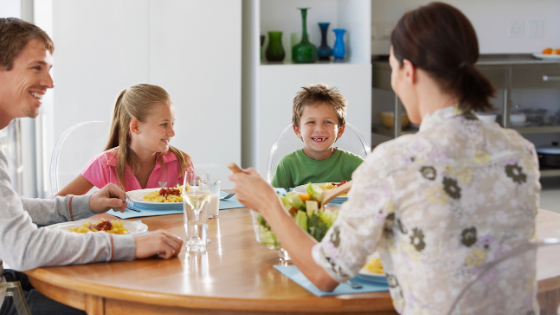 a family eating dinner together for intuitive eating principle of trusting their fullness and choices