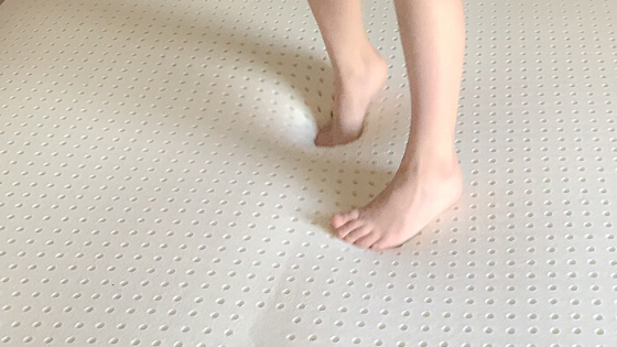 child standing on the mattress topper