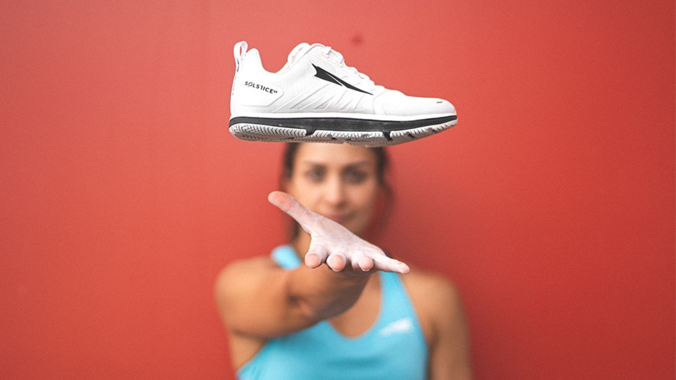 woman tossing workout shoe in air