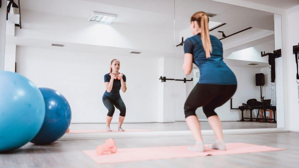 woman working out in front of a mirror