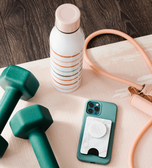 green weights and phone with pale pink yoga mat and water bottle tons of goddness